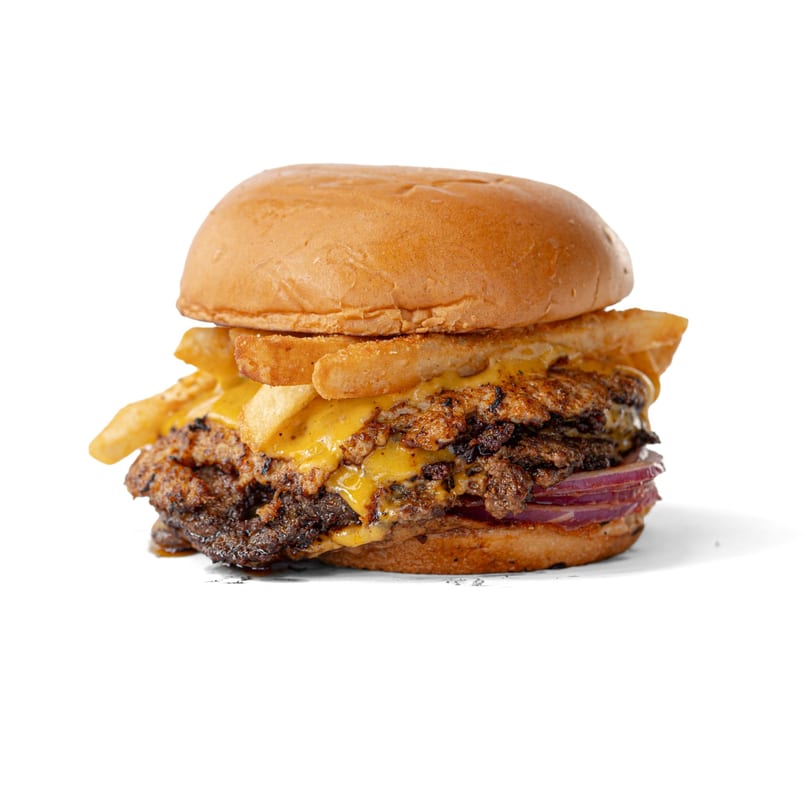 A double smash burger with melted cheese, red onions, and fries on a bun.